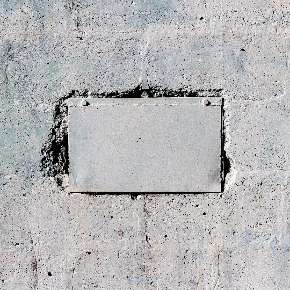 White metal plate on the old concrete wall
